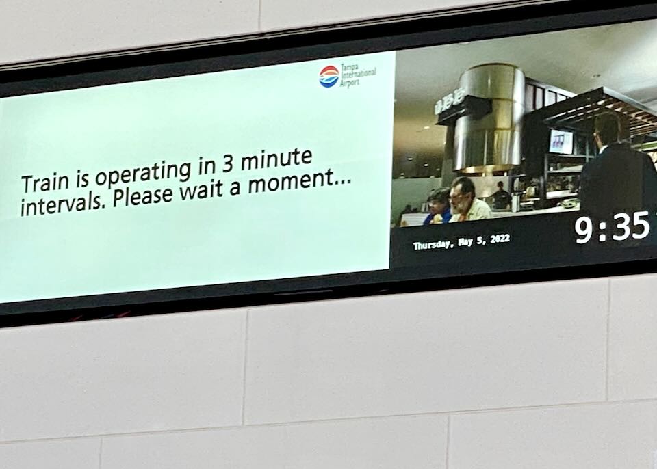A sign says, "Train is operating in 3-minute intervals. Please wait a moment."