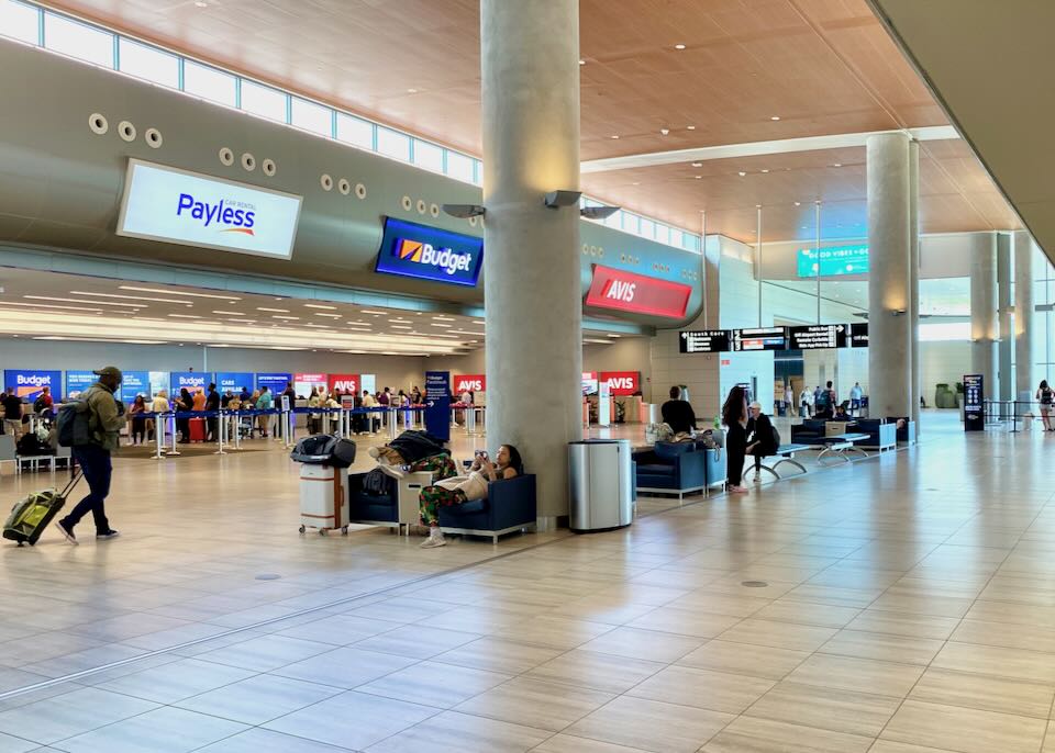Inside the Rental Car Center, Payless, Budget, and Avis rental counters line the walls.