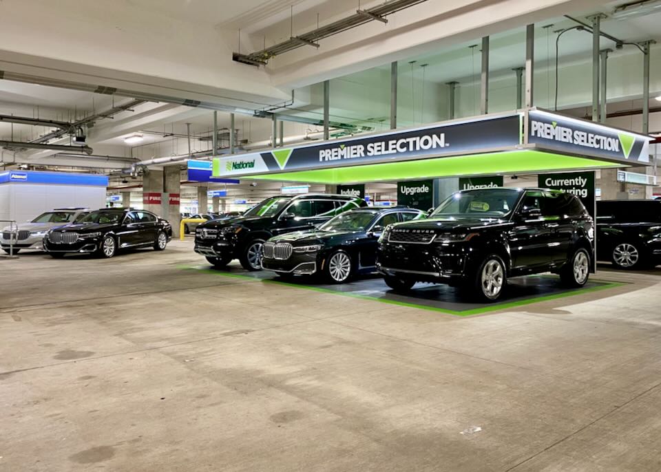 Luxury vehicles sit parked in the Premier selection section at National in the garage.