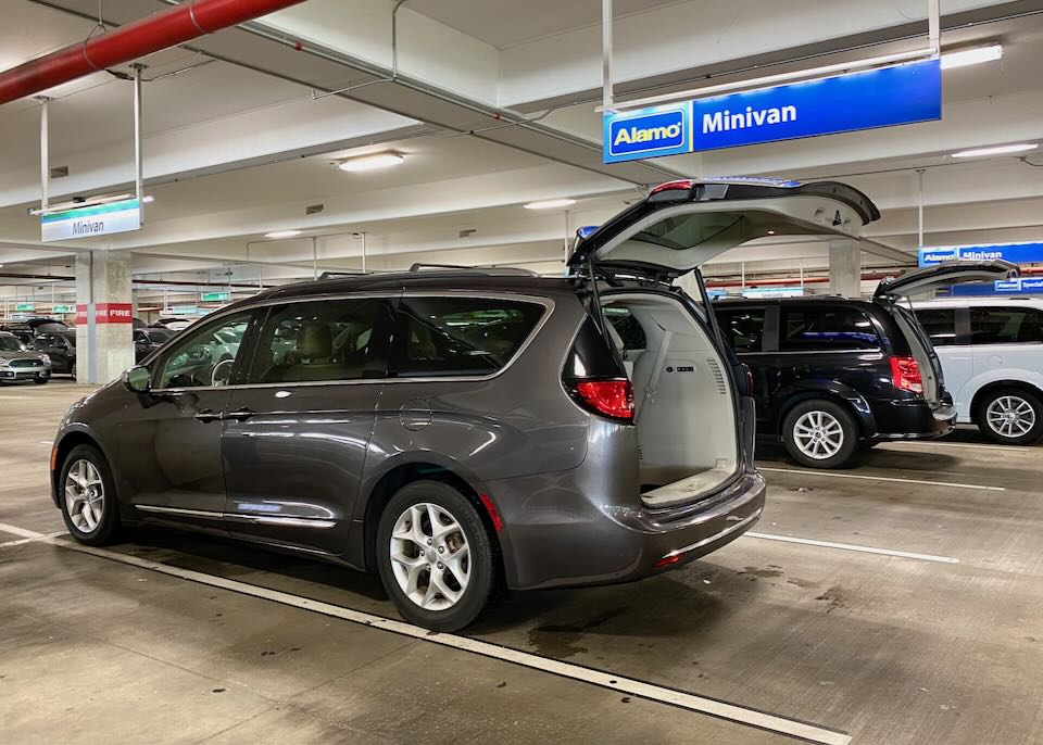 A minivan with its hatch-back open sits parked in the Alamo section of the garage.