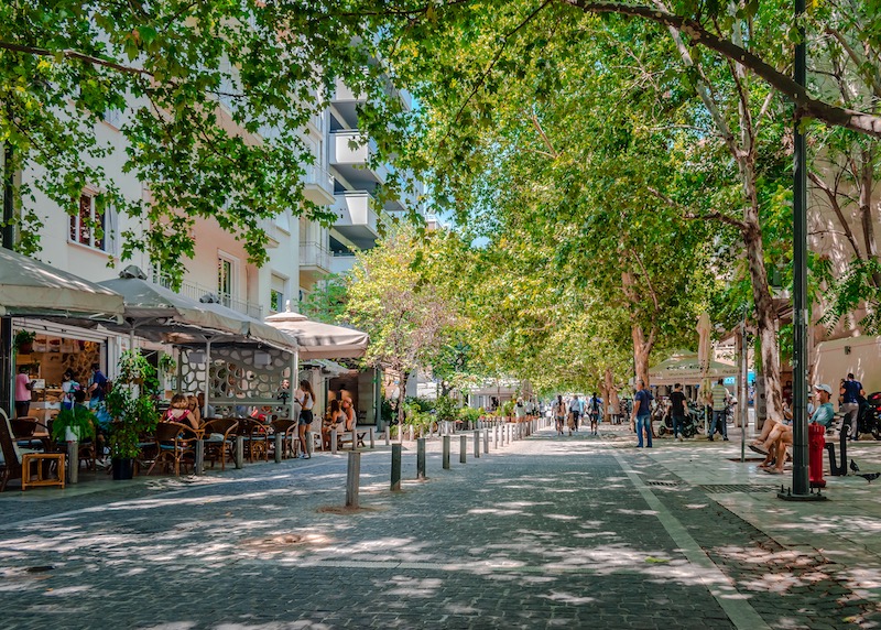 A tree-shaded street with cafes in Makriyanni, Athens