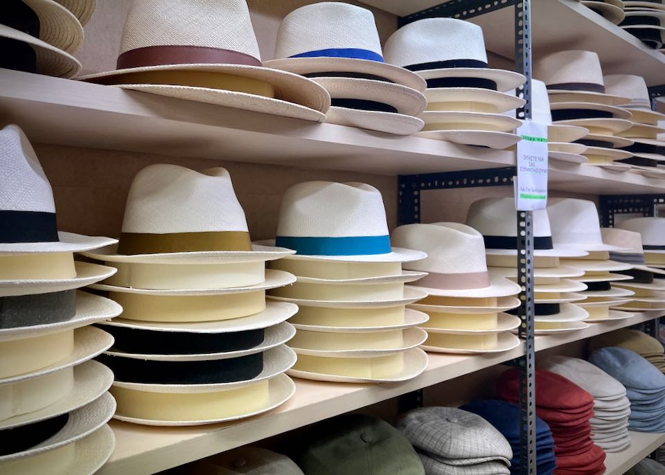Stacks of white straw fedoras with colorful bands