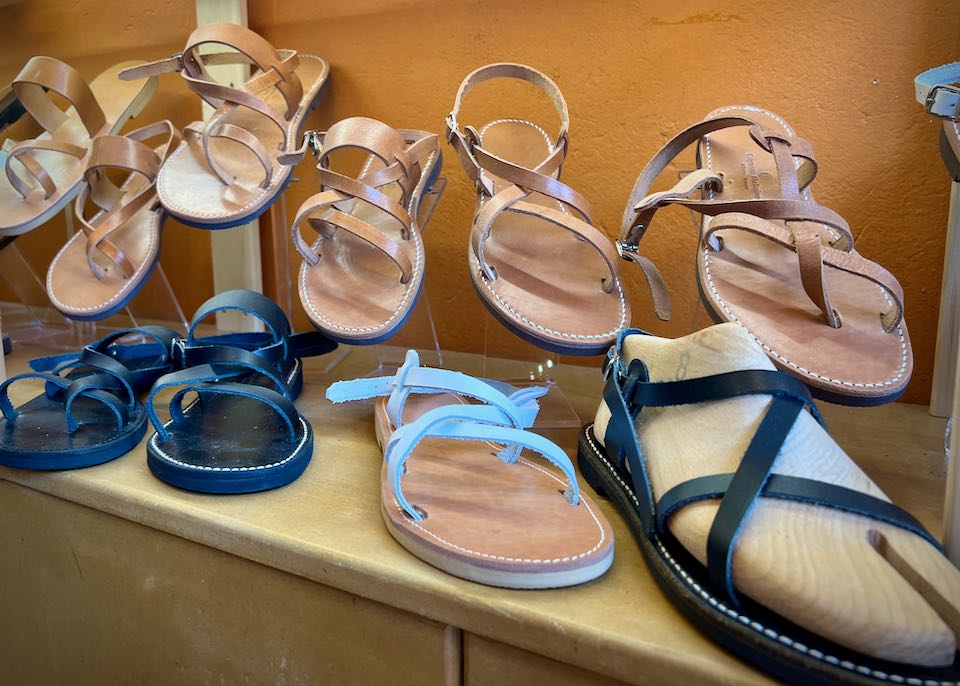 A variety of leather sandals on display on a shop shelf.