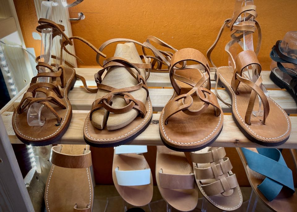 A variety of leather sandals on display on a shop shelf.