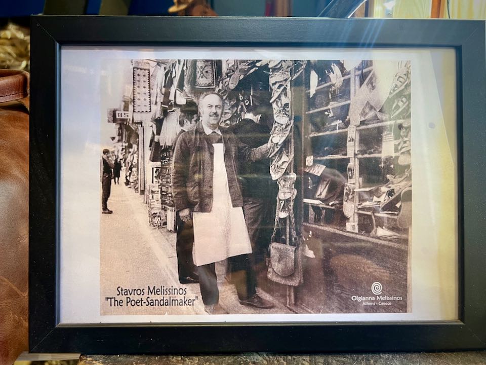 Framed black and white photo of a cobbler in front of his shop