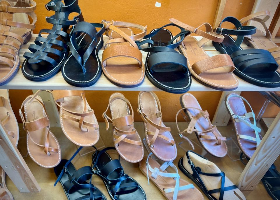 A variety of Greek sandals on display on a shop shelf