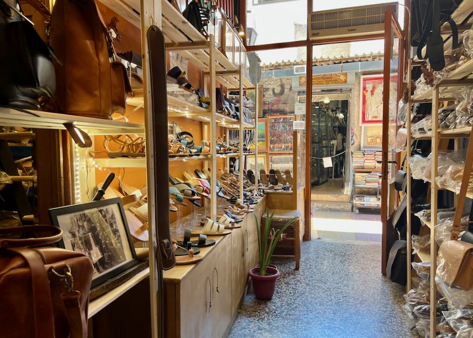 a shop display of leather sandals, bags, and belts