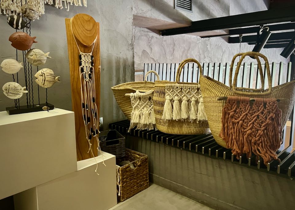 Macrame and woven handbags on a gallery shelf
