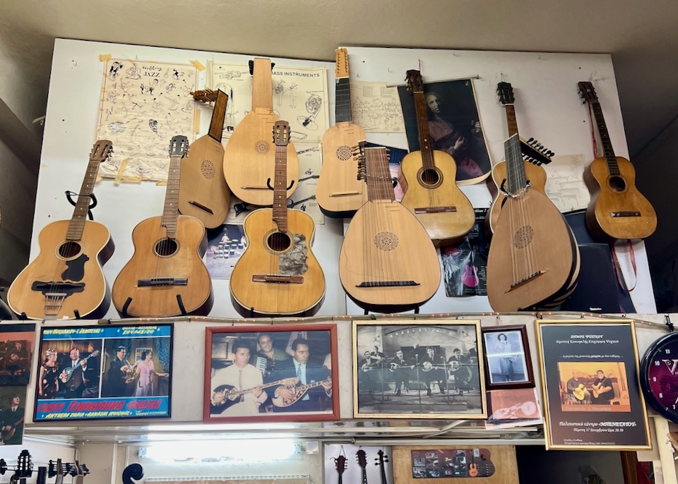 Guitars and other stringed instruments hanging high on a shop wall