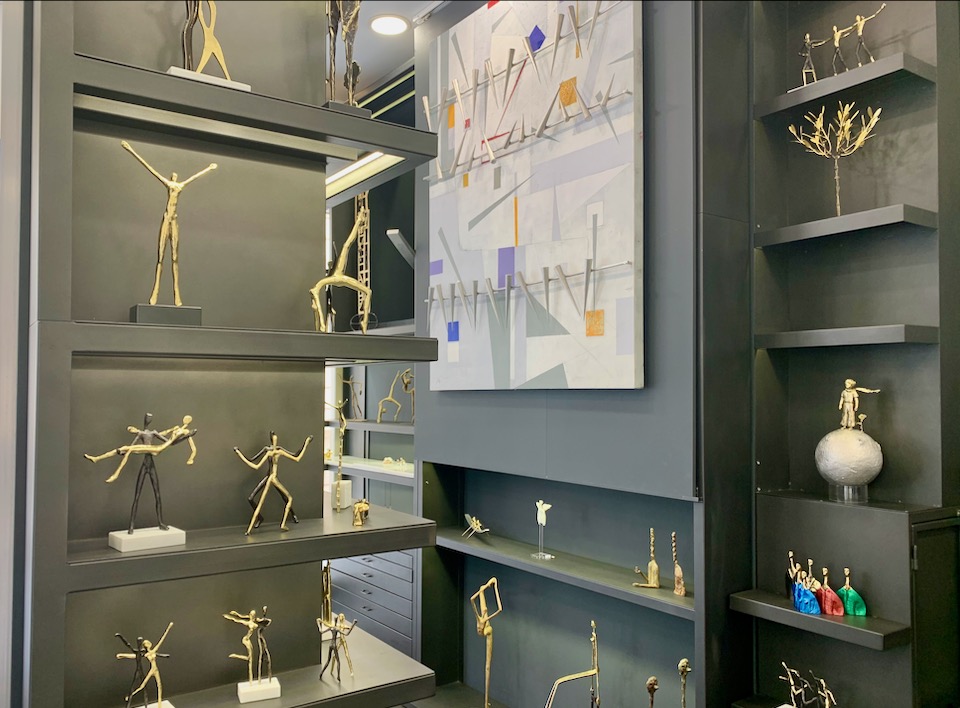 Metal human figures displayed on a shelf