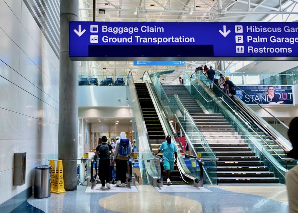 Overhead airport signs point in the direction of Ground Transportation.