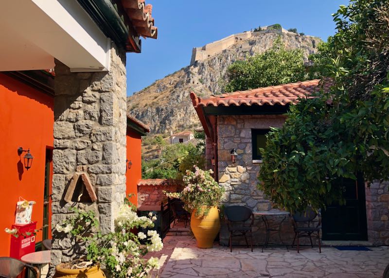tone courtyard with potted plants and views out to Palamidi fortress in Nafplio