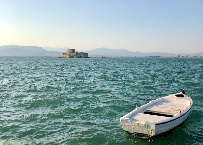 The island castle of Boutrzi, outside of Nafplio, Greece, with a rowboat in the foreground