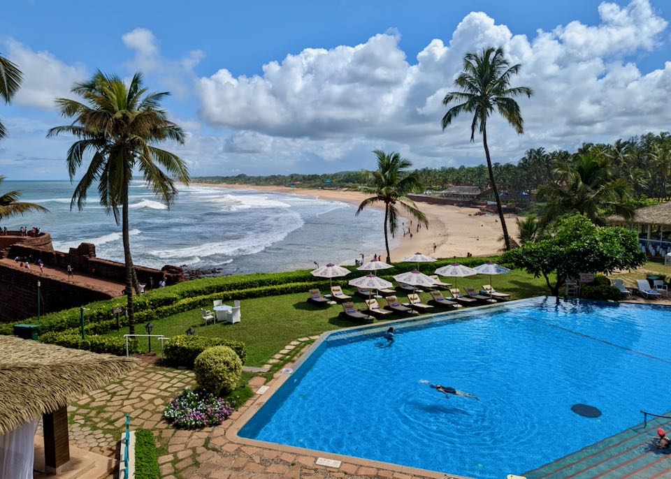 Goa resort on beach with pool.