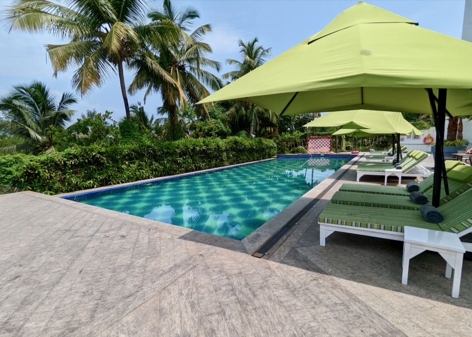 Luxury hotel in Goa with pool and view of beach.