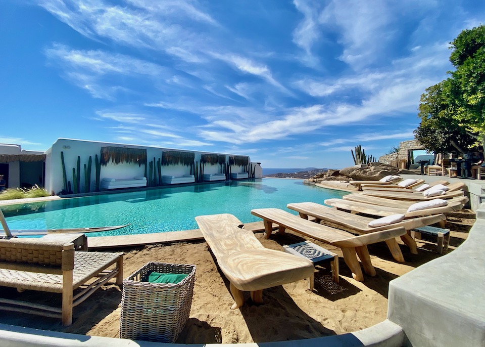 Sandy pool deck with sun loungers at Panoptis Escape above Elia Beach in Mykonos