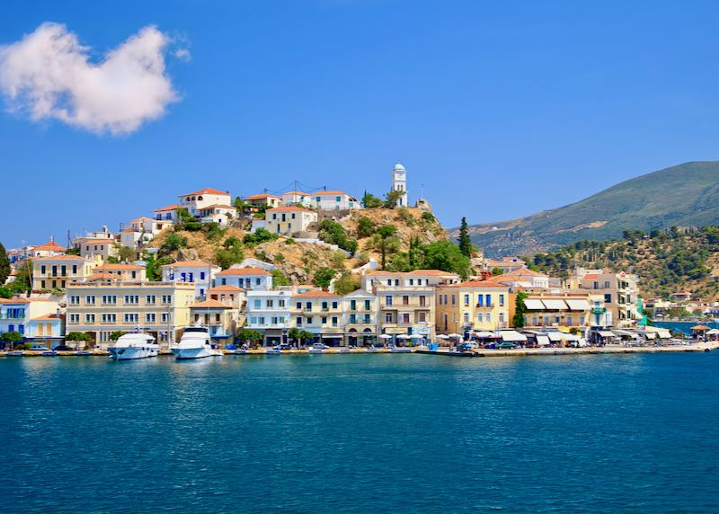 Colorful buildings on the harbor of the Greek island of Poros at sunny day