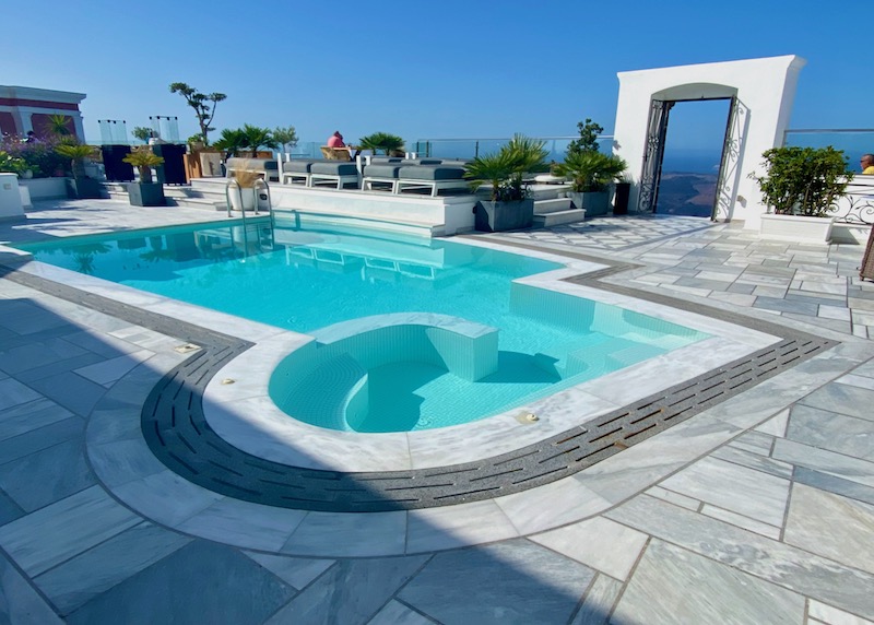 The pool of Anteliz Suites in Firostefani has a built-in jacuzzi