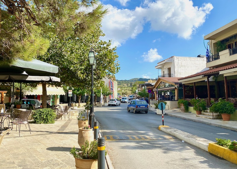 The main street through Archanes with a tree-filled square in Crete