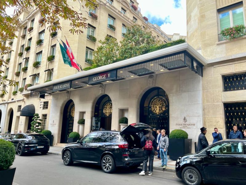People unload luggage from a car trunk at the ornate entrance to the Four Seasons Hotel in Paris. 
