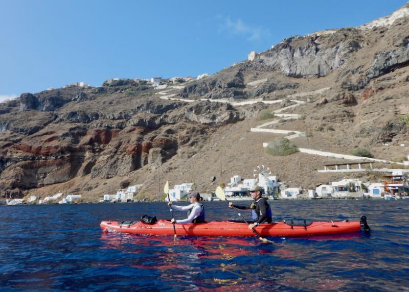 Kayakers tour in the Santorini caldera with Thirassia in the background