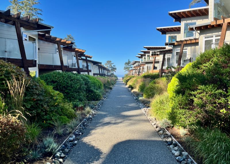 Paved path leading to the beach, lined with identical cottages.