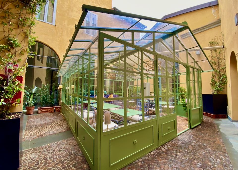 Glass-enclosed greenhouse in a central hotel courtyard 