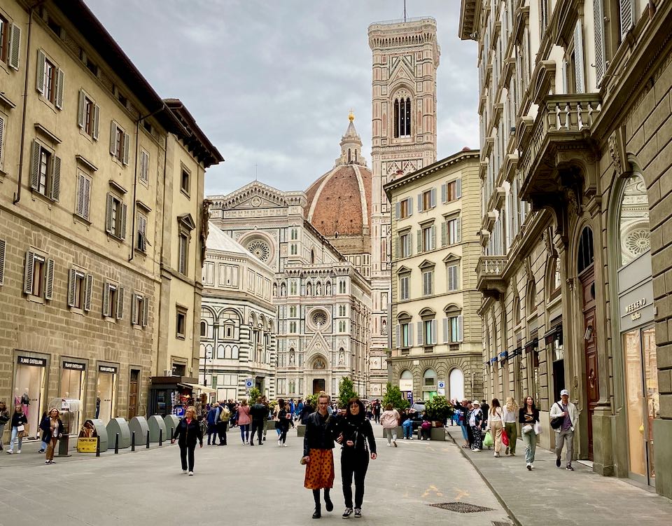 View of pedestrians walking down a side street away from the Piazza Del Duomo in Florence