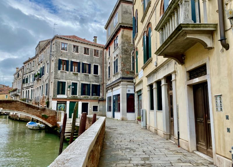 View along the pathway of a narrow canal in Venice