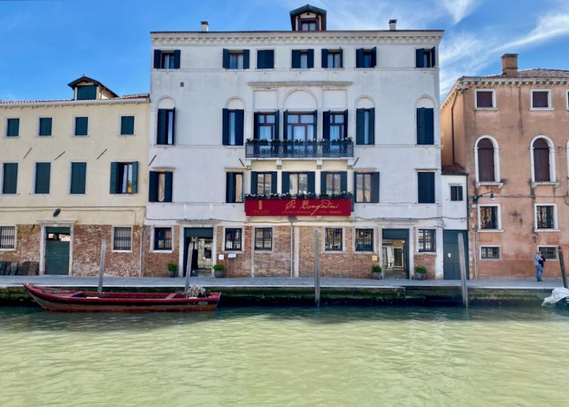 View of a historic hotel across a narrow canal in Venice