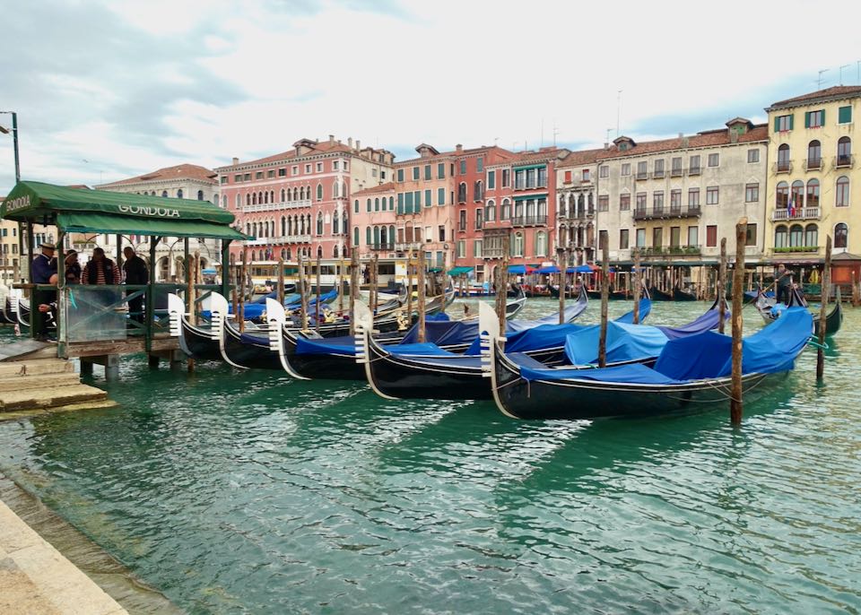 A line of empty gondolas waits for passengers on a Venetian canal
