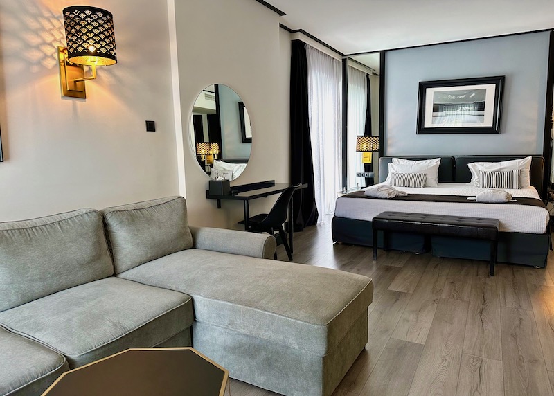 A junior suite with a king bed and sofa bed at the Athenian Riviera hotel in Vouliagmeni, Greece