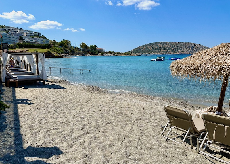 A sandy beach with beach cabanas and sunbeds at Vincci EverEden resort in the Athens Riviera