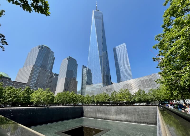 Skyscrapers rise behind the inverted fountain of the 911 memorial in New York City