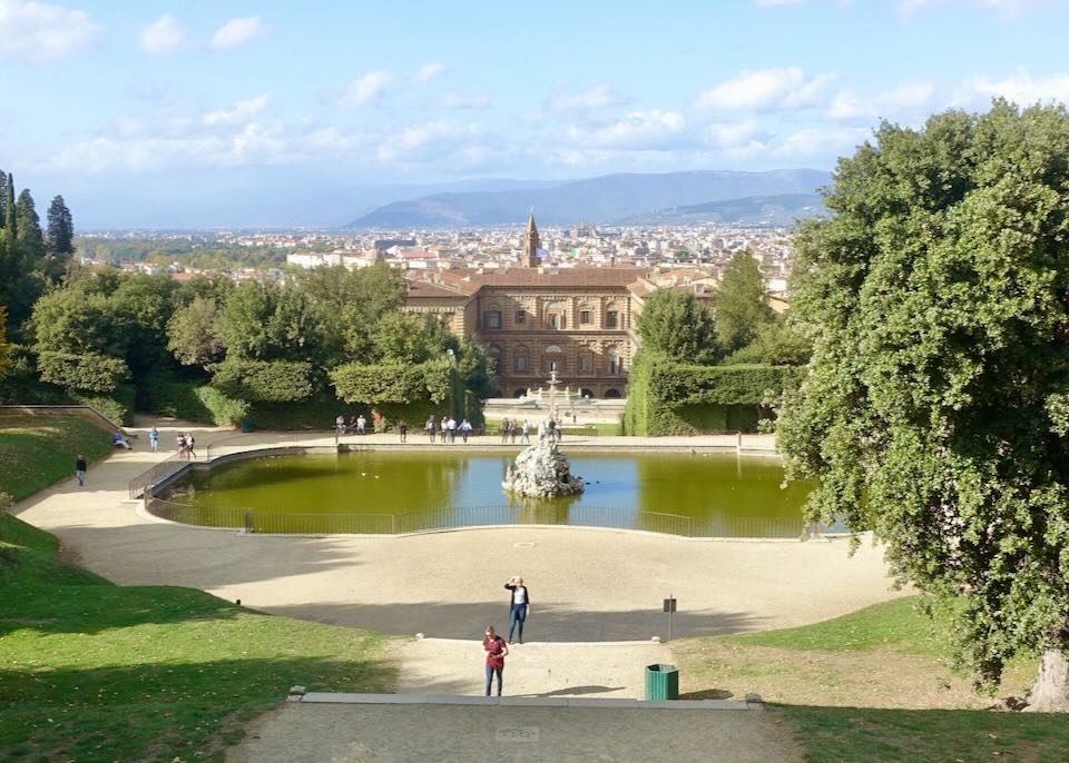 Tourists take a photo at a fountain in the Boboli Gardens of Florence, Italy
