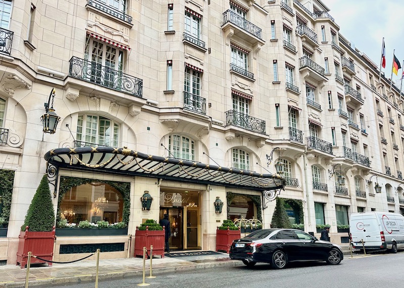 Le Bristol hotel with wrought iron balconies, a glass canopy, and stone facade in Paris