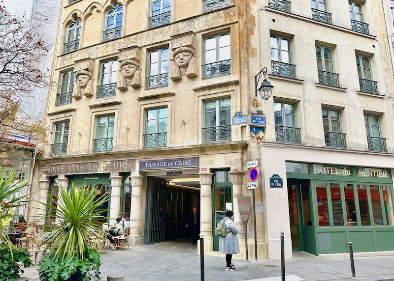 The Hotel du Sentier with three Egyptian heads of Hathor on the facade and wrought iron balconies in Paris.