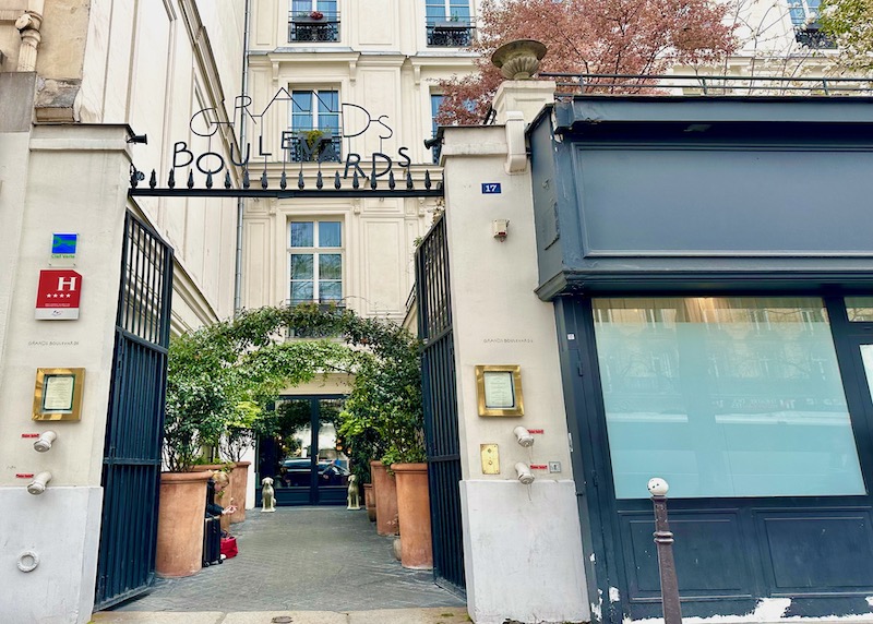 The open front gate and leafy arbors at the Grands Boulevards hotel in Paris