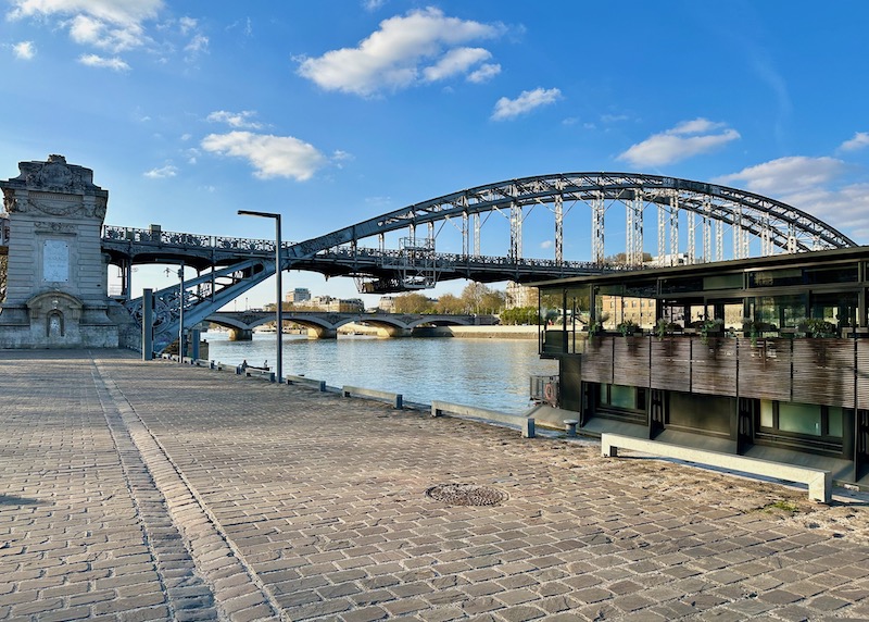 OFF boat hotel moored on the Seine facing the metal arch of the Austerlitz viaduct and the bridge beyond in Paris