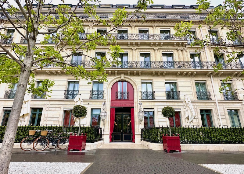 A tall red door at the etrance of La Reserve hotel in Paris