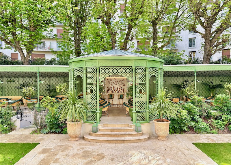 The bright green garden bar set in a gazebo with plants and flowers at the Saint James hotel in Paris