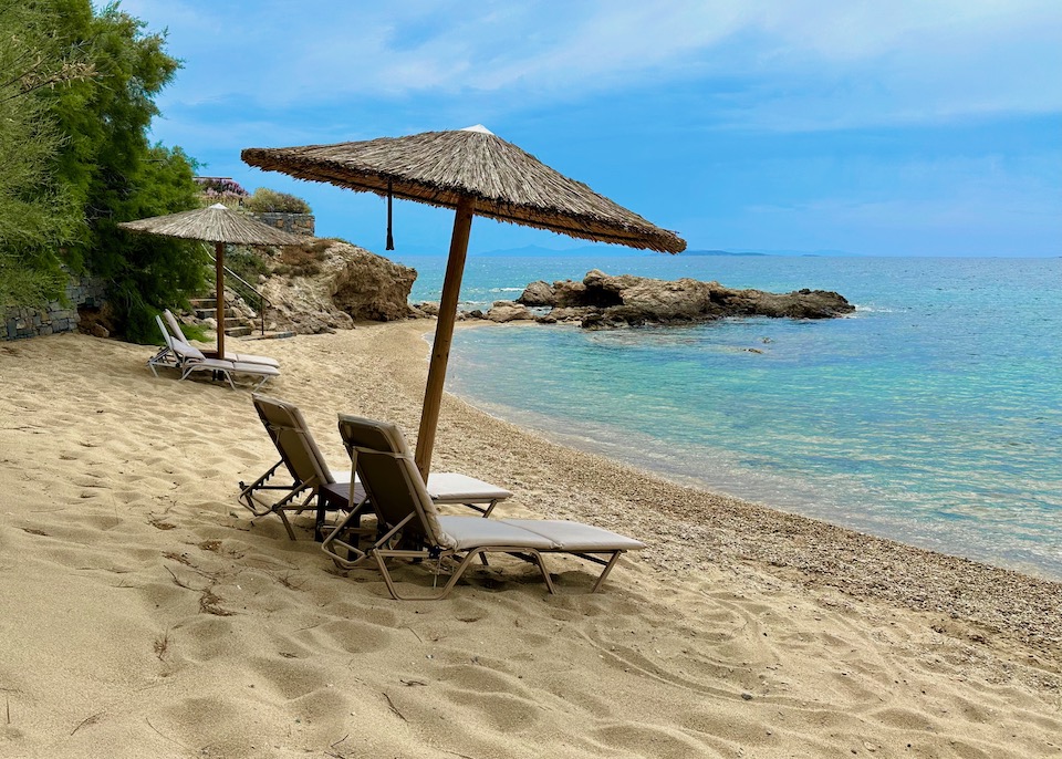 A small private beach with sunbeds and umbrellas at Grand Resort Lagonissi on the Athens Riviera