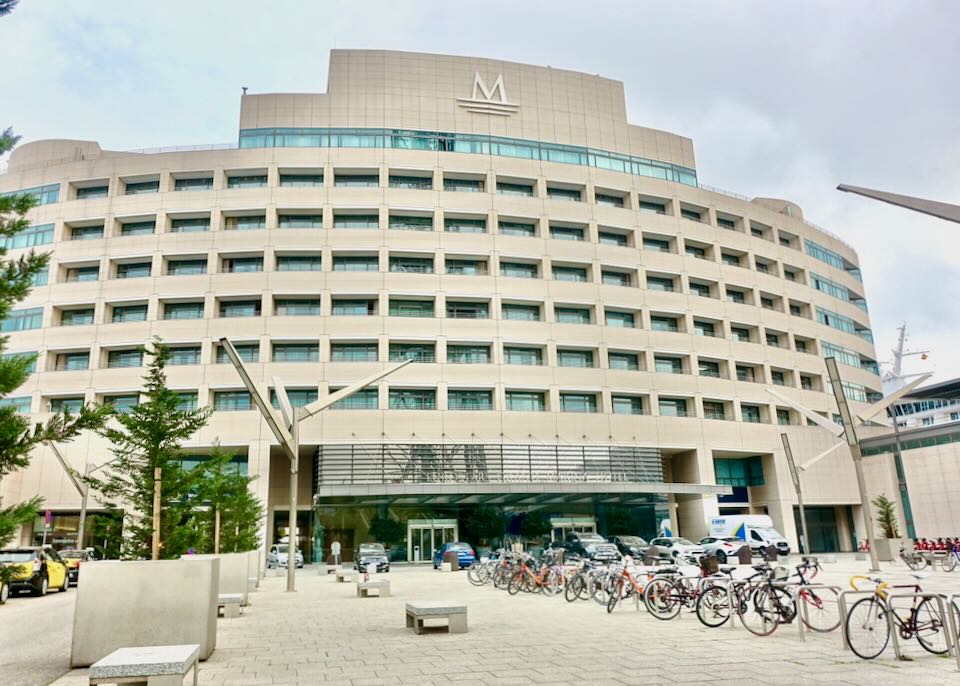 Large white hotel building with bicycles parked in front