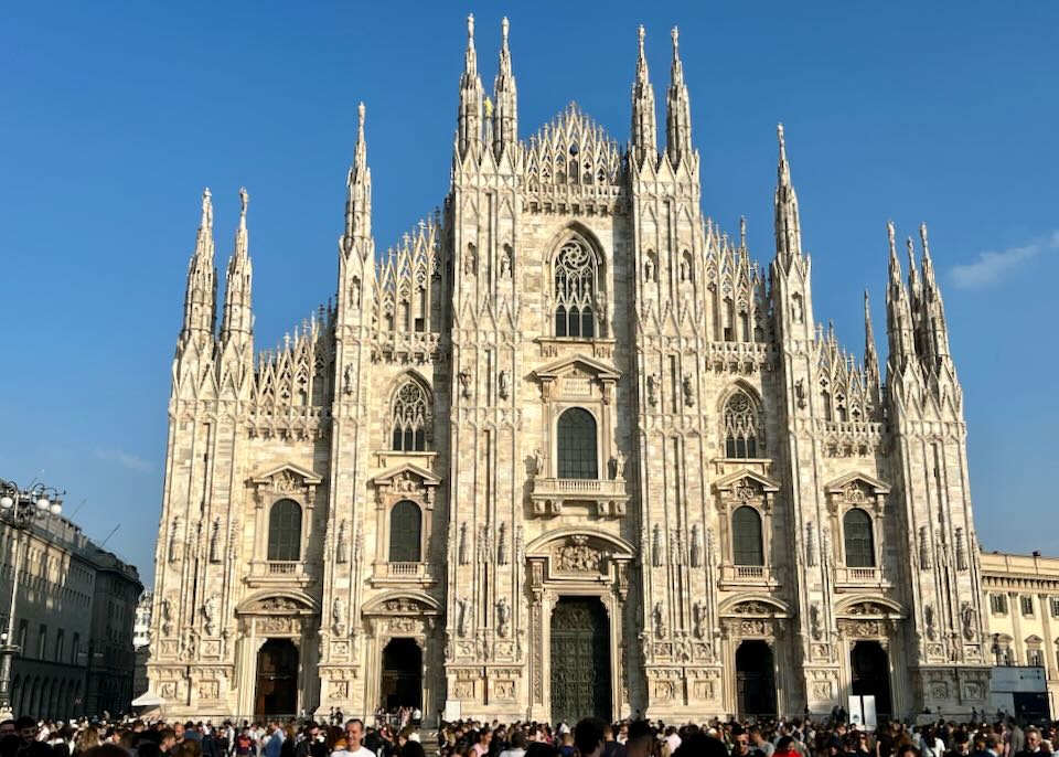 Front view of Milan's gothic-spired duomo cathedral on a sunny day