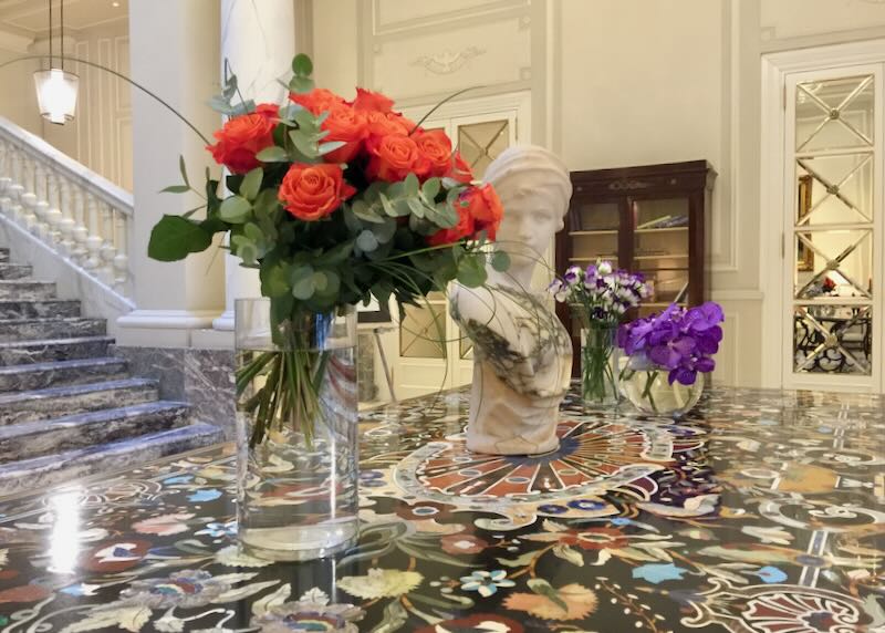 Display of cut flowers in front of a grand marble staircase