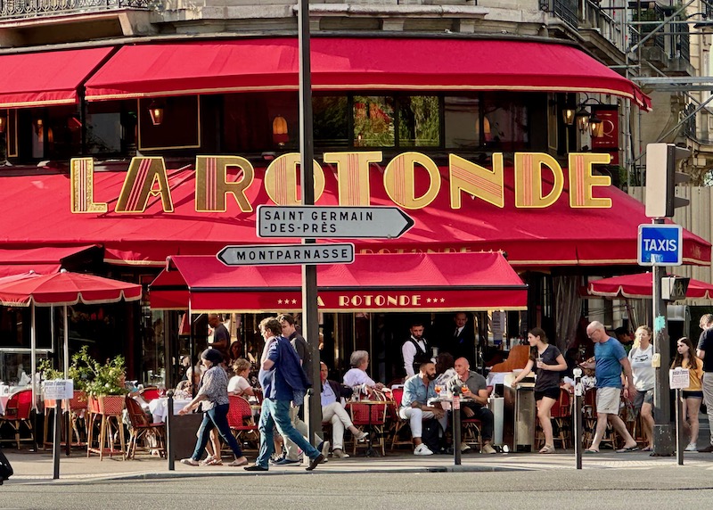 Landmark restaurant in red with a gold La Rotonde sign in front in Montparnasse, Paris