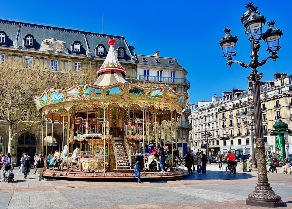 Colorful carousel in front of a Haussmann-style building in Paris