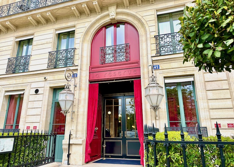 The red arched doorway and velvet curtain at the entrance of La Reserve hotel in Paris