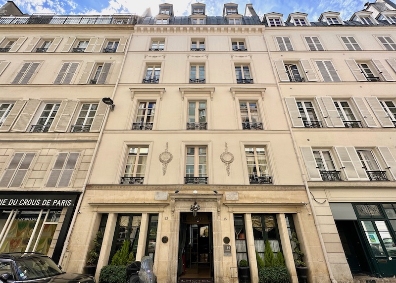 Haussmann-style exterior of L'Hotel with dormer windows on top, wrought iron Juliet balconies in the 6th Arrondissement of Paris