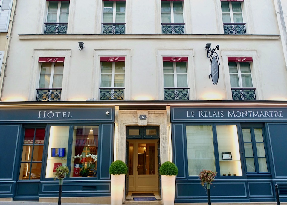 The understated exterior of the Hotel Le Relais Montmartre in Paris, blue on the ground floor and white upper floors
